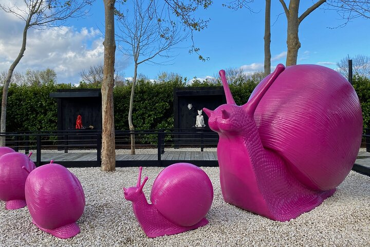 Explore a whimsical outdoor space where oversized pink snails invite curiosity blending creativity with nature amidst stunning sculptures and serene gardens in Matakana. A journey for the senses awaits.